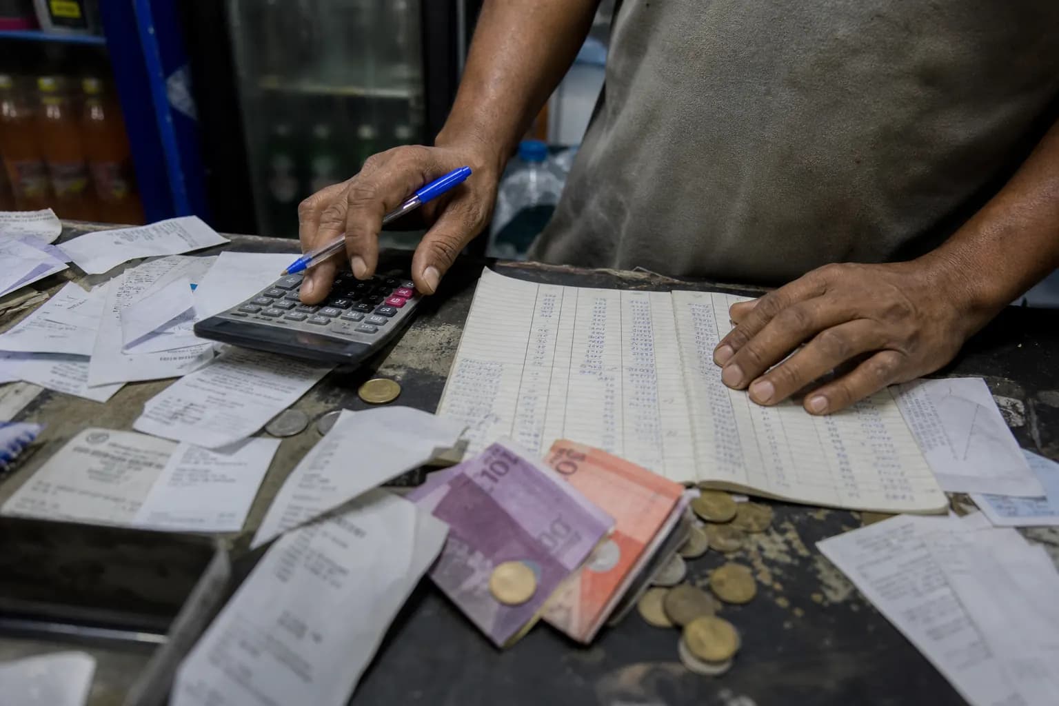 Cierre de caja con recibos sueltos, cuaderno manuscrito y efectivo sin cuadrar.